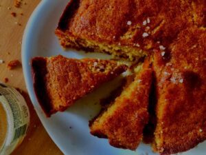 Close-up of a slice of honey and herb cake with a glistening salted honey drizzle